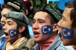 A Chinese Uighur chants slogans in front